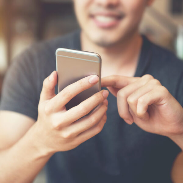Happy,Male,Using,Smartphone,At,Modern,Coffee,Shop,,He,Chatting